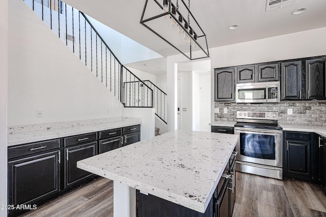 15365 W Valentine St, Surprise, AZ 85379 - kitchen featuring appliances with stainless steel finishes, dark cabinets, dark wood-style flooring, and a center island