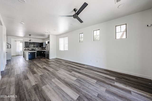 15365 W Valentine St, Surprise, AZ 85379 - unfurnished living room with ceiling fan, baseboards, and dark wood-style floors