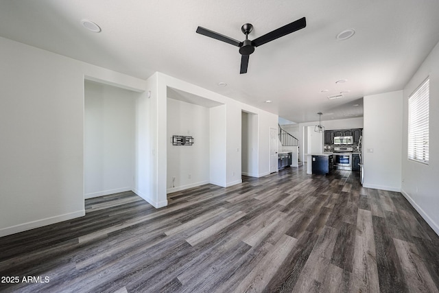 15365 W Valentine St, Surprise, AZ 85379 - unfurnished living room with ceiling fan, stairway, dark wood-style flooring, and baseboards