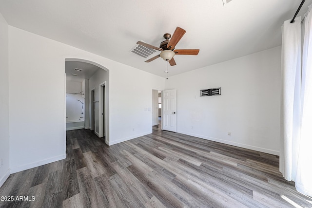 15365 W Valentine St, Surprise, AZ 85379 - empty room with arched walkways, wood finished floors, ceiling fan, and baseboards
