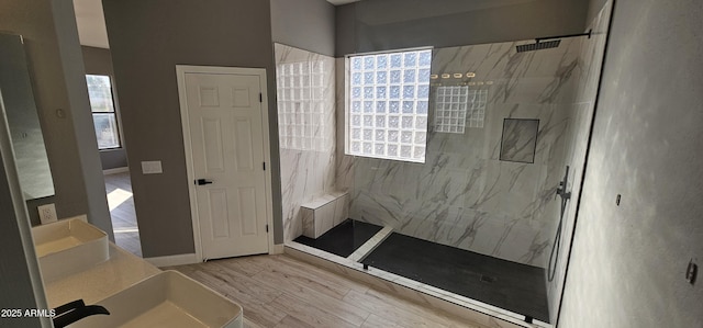 bathroom featuring tiled shower, wood-type flooring, and vanity