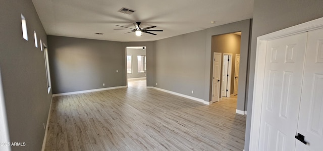 unfurnished room featuring ceiling fan, plenty of natural light, and light wood-type flooring