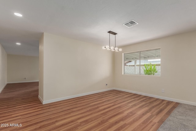 unfurnished room with recessed lighting, visible vents, light wood-style flooring, and baseboards