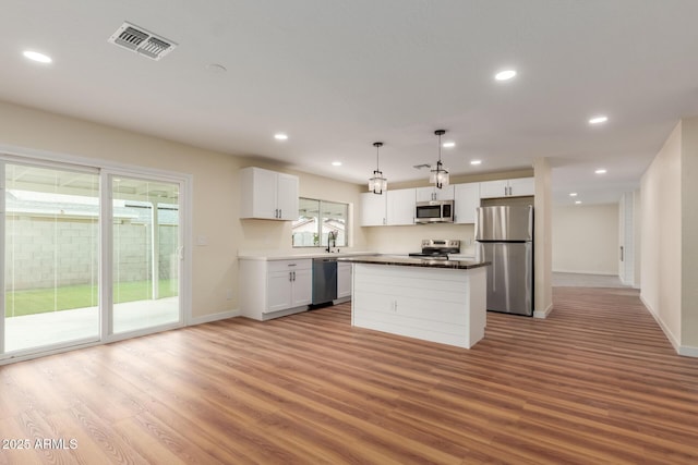 kitchen featuring light wood-type flooring, visible vents, appliances with stainless steel finishes, and a center island