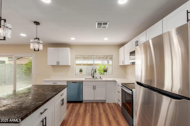 kitchen with visible vents, a healthy amount of sunlight, stainless steel appliances, and a sink