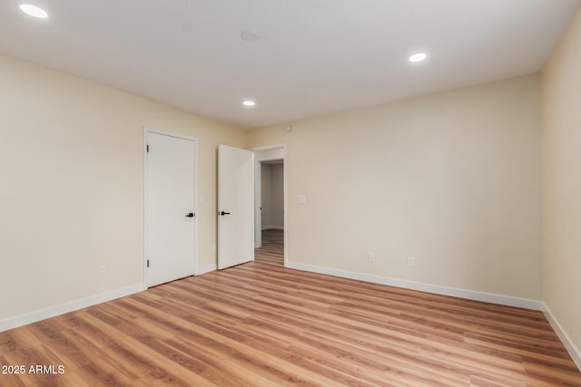 spare room featuring recessed lighting, baseboards, and light wood-style floors