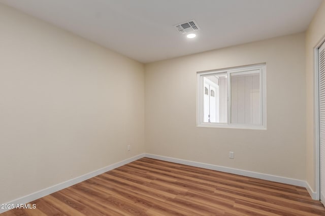 empty room with recessed lighting, visible vents, light wood-style flooring, and baseboards