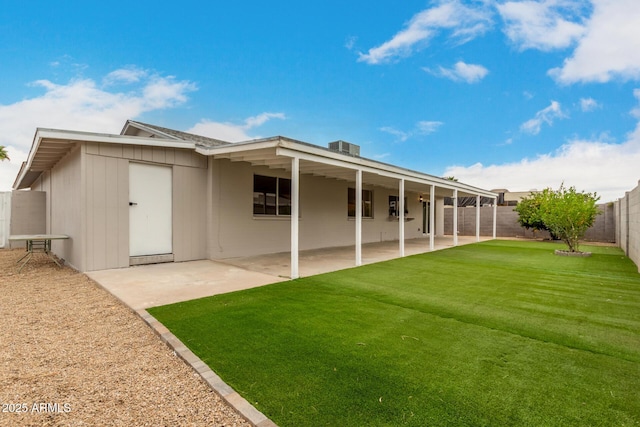 rear view of house featuring a lawn, a fenced backyard, and a patio area