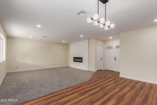 unfurnished living room featuring visible vents, a large fireplace, baseboards, recessed lighting, and wood finished floors