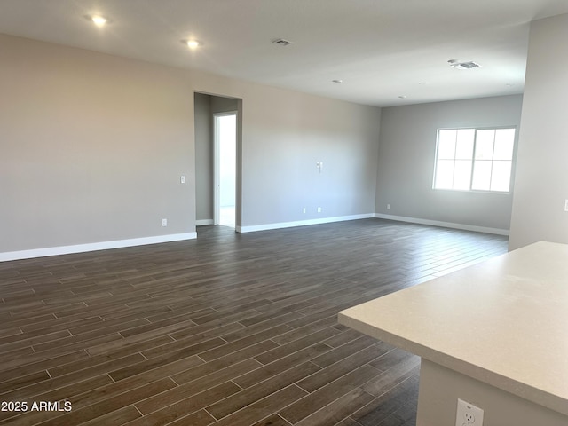 spare room with visible vents, baseboards, dark wood-style flooring, and recessed lighting