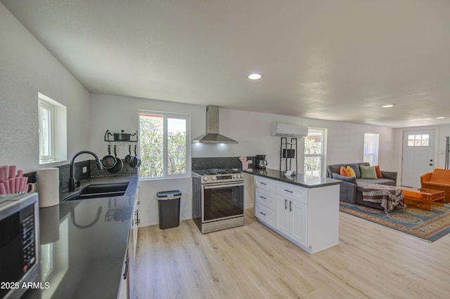 520 S Macdonald, Mesa, AZ 85210 - kitchen with gas stove, wall chimney range hood, a sink, light wood finished floors, and a wall unit AC