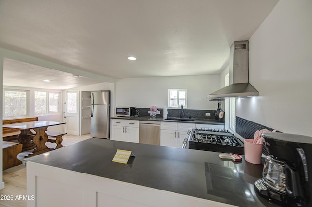 520 S Macdonald, Mesa, AZ 85210 - kitchen with wall chimney range hood, appliances with stainless steel finishes, a sink, dark countertops, and white cabinetry