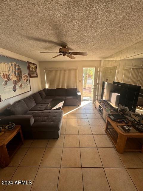 living room featuring ceiling fan, tile patterned flooring, and a textured ceiling