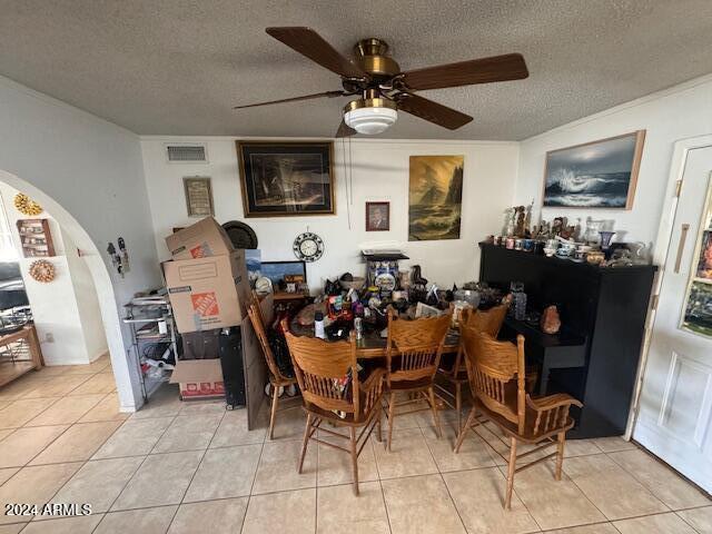 dining area with ceiling fan, light tile patterned floors, and a textured ceiling