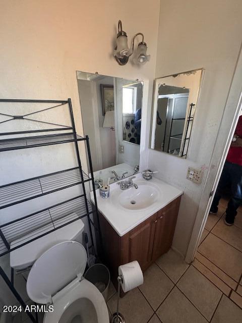 bathroom featuring tile patterned floors, vanity, and toilet