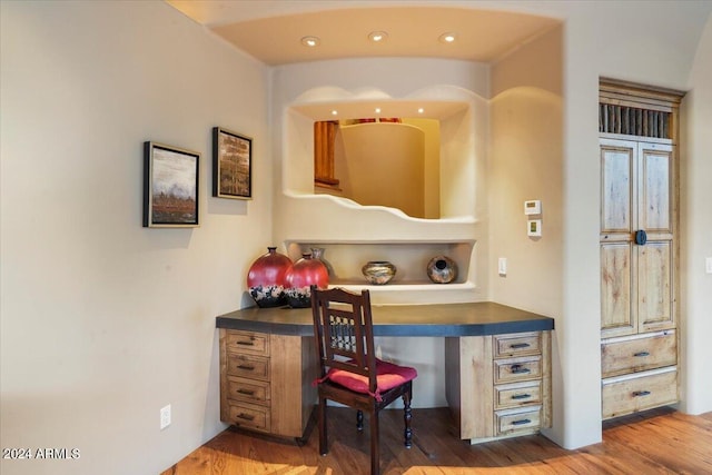 office space featuring built in desk and hardwood / wood-style flooring