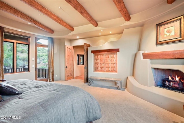 carpeted bedroom featuring access to exterior and beam ceiling