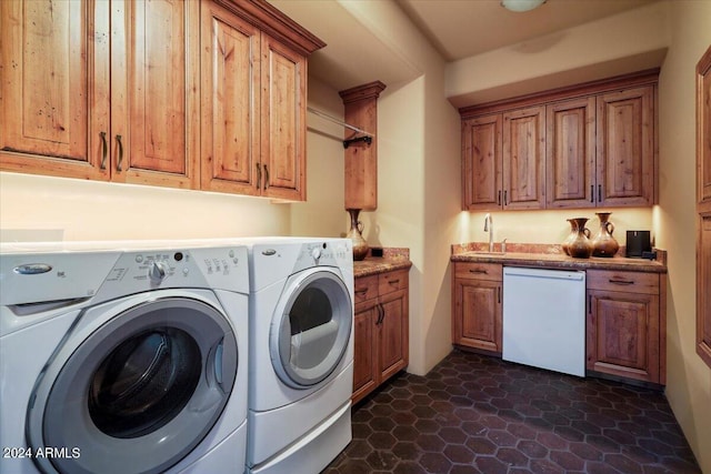 washroom featuring washer and dryer, sink, and dark tile flooring