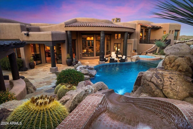 pool at dusk featuring a patio