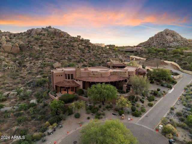 aerial view at dusk featuring a mountain view