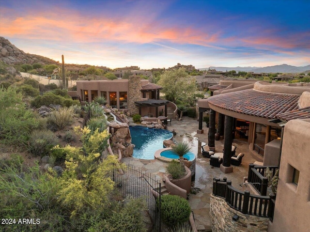 pool at dusk featuring a patio