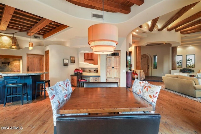 dining room featuring beamed ceiling and light hardwood / wood-style floors