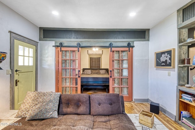 816 Tombstone Cyn Unit C, Bisbee, AZ 85603 - living room featuring a barn door, wood finished floors, a wall mounted AC, and recessed lighting