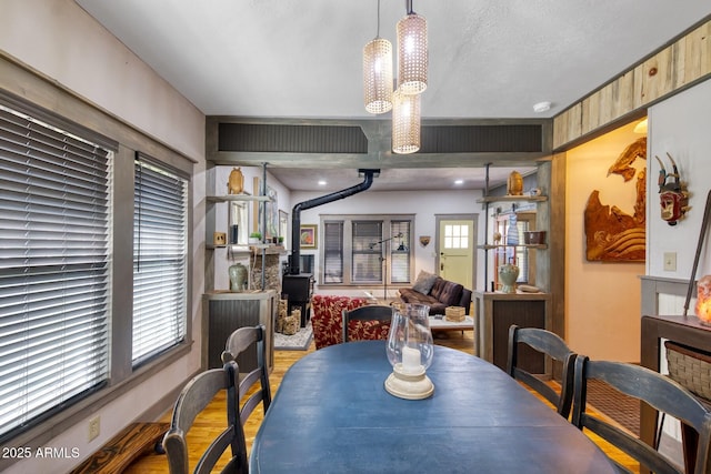 816 Tombstone Cyn Unit C, Bisbee, AZ 85603 - dining room featuring a wood stove, light wood-style flooring, and a chandelier