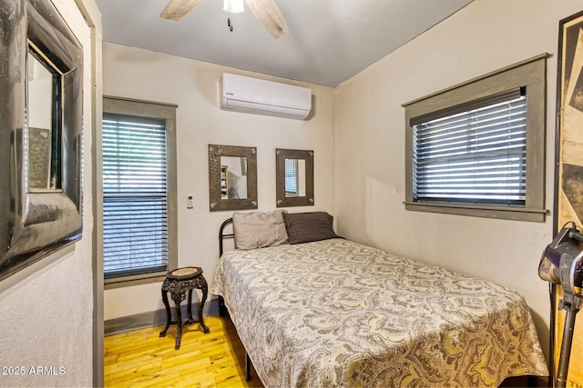 816 Tombstone Cyn Unit C, Bisbee, AZ 85603 - bedroom featuring a wall unit AC, wood finished floors, and a ceiling fan