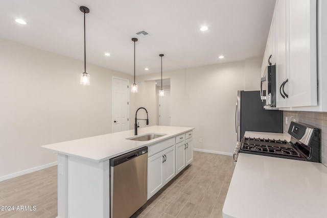 kitchen featuring a center island with sink, sink, stainless steel appliances, and hanging light fixtures