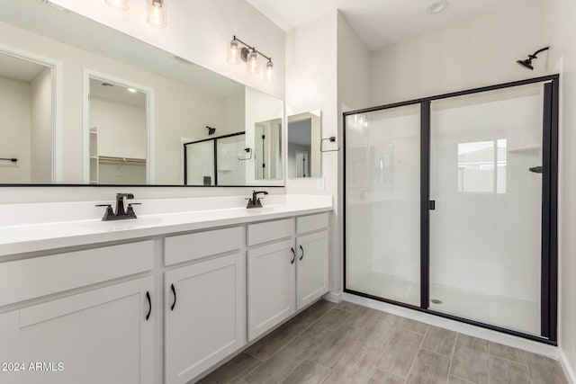 bathroom featuring hardwood / wood-style flooring, vanity, and walk in shower