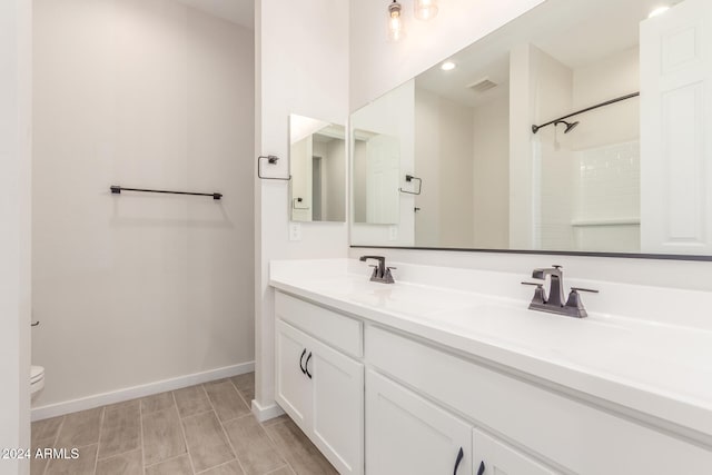 bathroom featuring wood-type flooring, vanity, toilet, and walk in shower