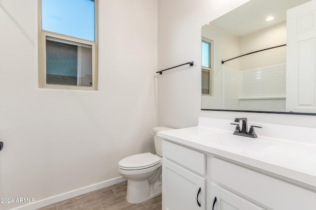 bathroom with a shower, toilet, vanity, and hardwood / wood-style flooring