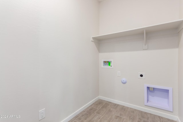 laundry area with washer hookup, hookup for a gas dryer, hookup for an electric dryer, and light hardwood / wood-style flooring