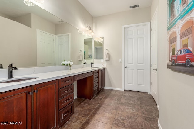 bathroom featuring visible vents, a sink, baseboards, and double vanity