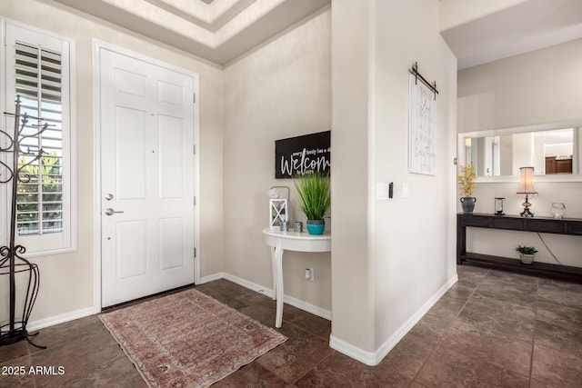 entrance foyer with baseboards and stone finish floor
