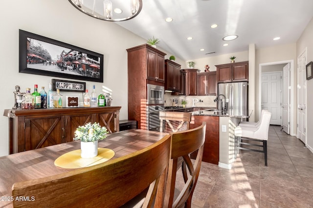 tiled dining room featuring recessed lighting, a sink, visible vents, and a bar