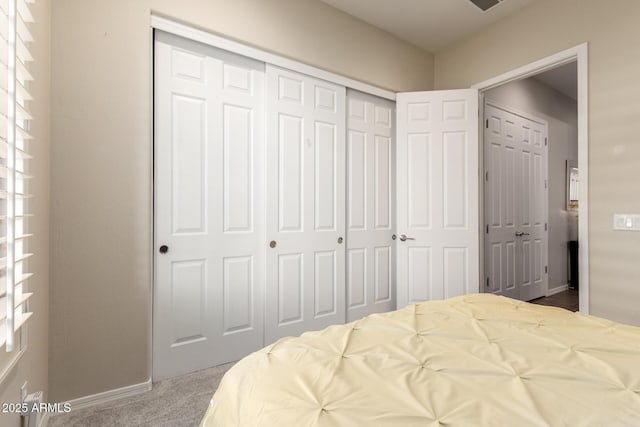 bedroom with baseboards, carpet, and a closet