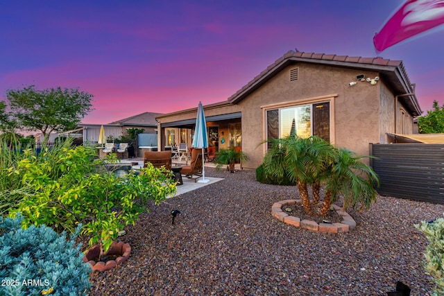 back of property featuring fence, a patio, and stucco siding