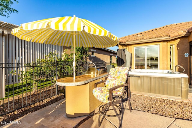 view of patio with area for grilling, fence, and exterior bar
