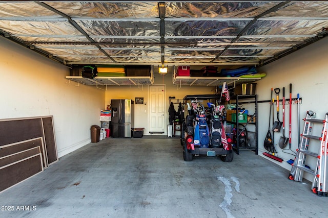 garage featuring stainless steel refrigerator with ice dispenser