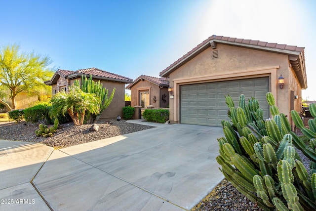 view of front facade featuring a garage, stucco siding, a tiled roof, and concrete driveway