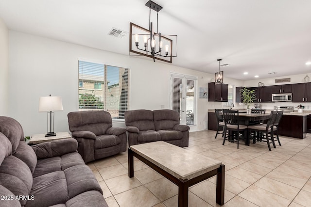 6746 W Wethersfield Rd, Peoria, AZ 85381 - living room featuring light tile patterned flooring, an inviting chandelier, visible vents, and recessed lighting