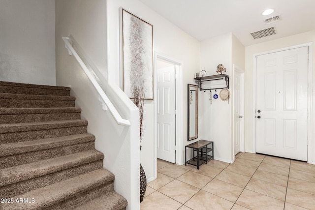 6746 W Wethersfield Rd, Peoria, AZ 85381 - entryway featuring light tile patterned floors, baseboards, visible vents, and stairway