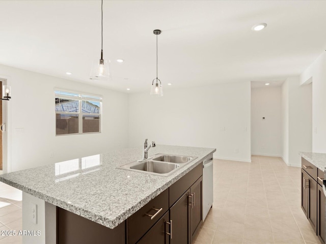 kitchen with dishwasher, an island with sink, sink, hanging light fixtures, and dark brown cabinetry