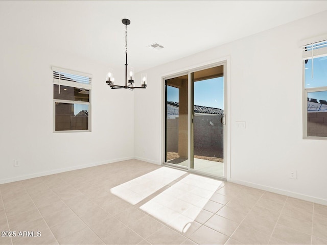 spare room with light tile patterned floors and a chandelier