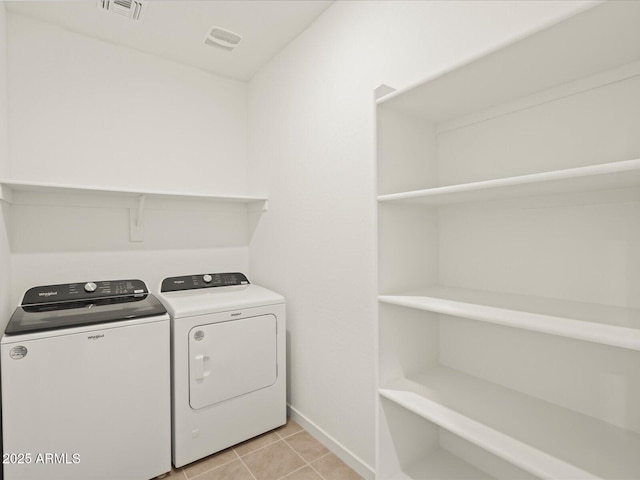 laundry area featuring light tile patterned flooring and washing machine and dryer