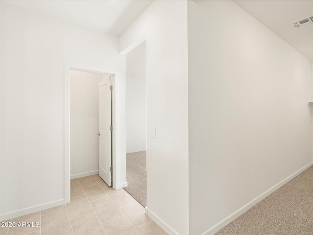 hallway featuring light colored carpet