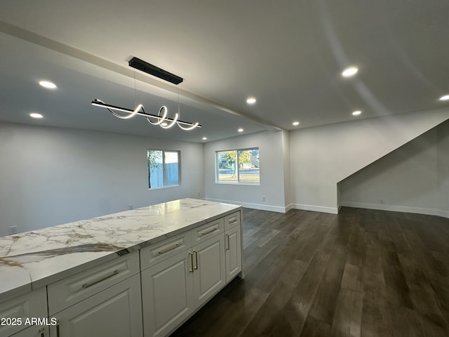 kitchen featuring an inviting chandelier, dark wood-type flooring, white cabinets, hanging light fixtures, and light stone counters