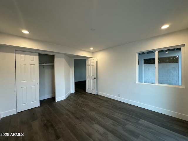 unfurnished bedroom with dark wood-type flooring and a closet